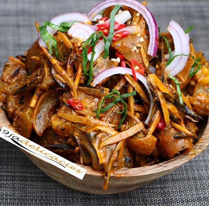 a wooden bowl filled with food on top of a table