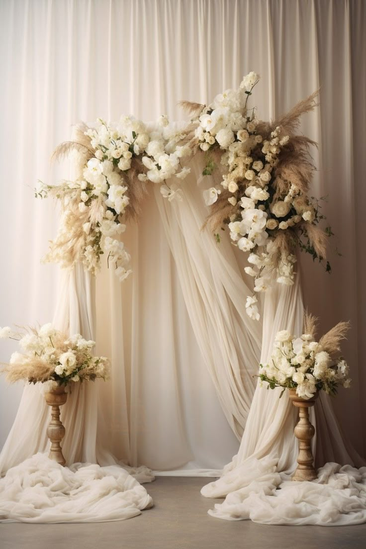 backdrop featuring a boho wedding arch draped with flowing neutral-toned fabric and adorned with white flowers Wedding Draping Backdrop Ceremony Arch, Boho Style Engagement Decor, Elegant Wedding Arch Indoor, Boho Theme Wedding Backdrop, Beige Wedding Arch, Beige Wedding Backdrop, Neutral Wedding Backdrop, Wedding Arch Ideas White, Fabric Arch Backdrop