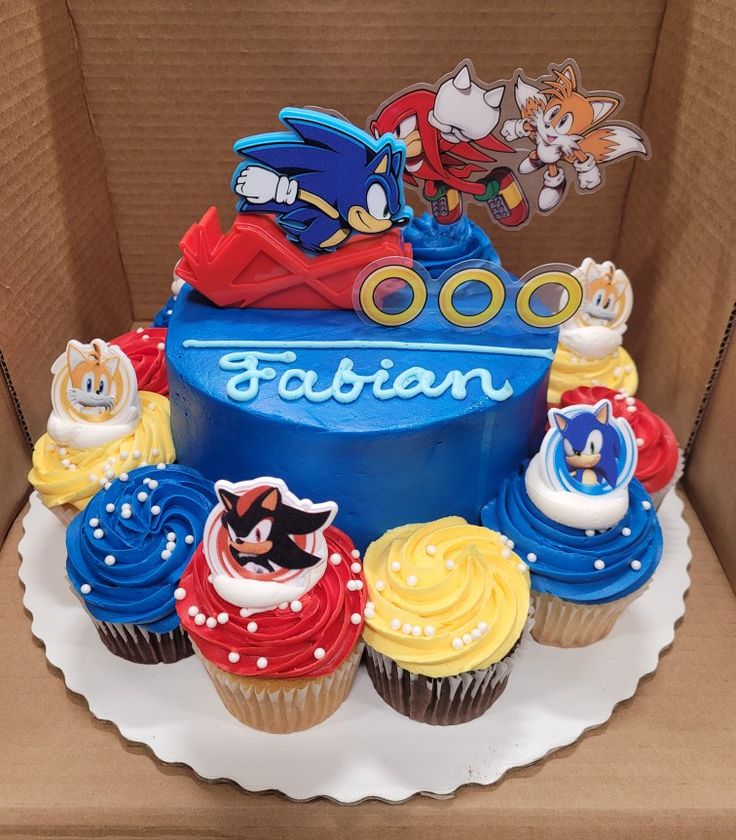 a birthday cake made to look like sonic the hedgehog with cupcakes on it