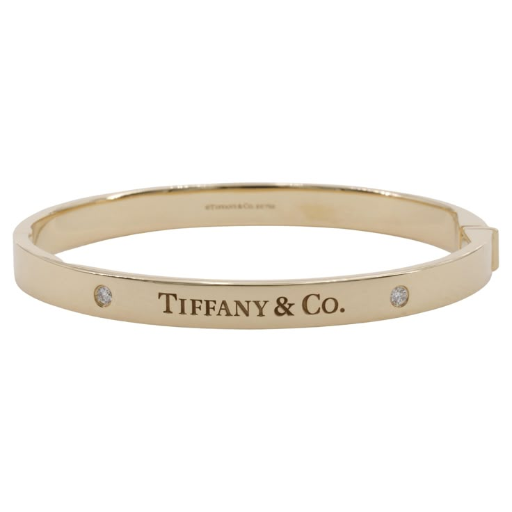 Tiffany & Co. 1837 Diamond Hinged Bangle in 18 Karat Yellow Gold An iconic and well made diamond and 18 karat yellow gold bangle by Tiffany & Co. Includes original Tiffany & Co. jewelry pouch. Bangle - Metal - 18k Yellow gold Weight - 33.0 Grams Width - 6 millimeters Opening - Approximately 2 inches x 2.5 inches Hallmarks - Tiffany & Co. / AU750 Diamonds Weight - 0.10ctw Shape - Round Brilliant Cut Clarity - VS1+ Color - D to F Tiffany Jewellery, Gold Tiffany, Tiffany And Co Bracelet Gold, Gold Tiffany Bracelet, Tiffany And Co Gold Bracelet, Tiffany T Bangle, Tiffany Bracelet, Tiffany & Co. Bracelet, Jewelry Bracelets Gold Tiffany & Co.