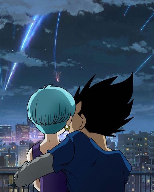 two people standing next to each other in front of a city skyline with fireworks behind them