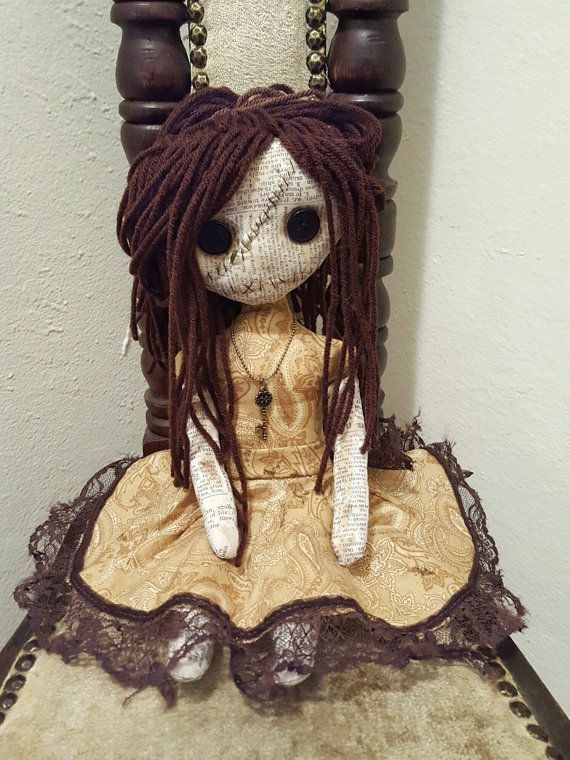 a doll with dreadlocks sitting on top of a wooden chair next to a wall