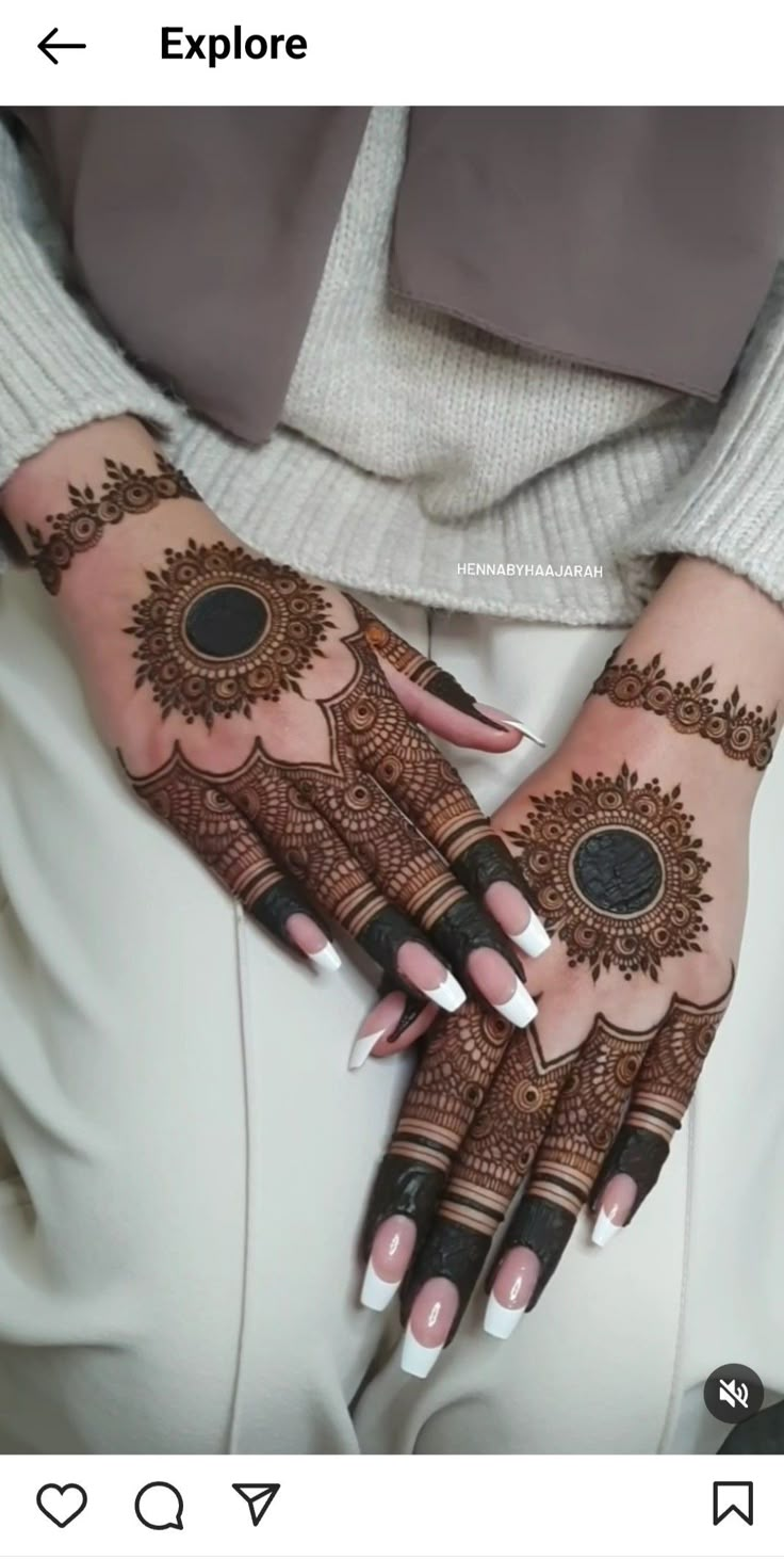 a woman's hands with henna tattoos on them