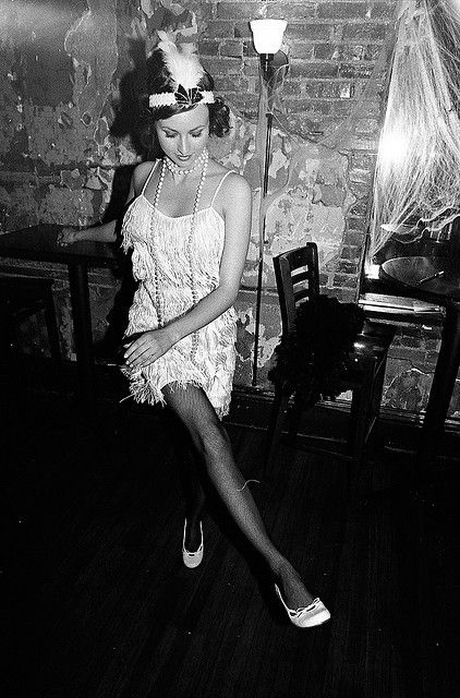 a woman standing in front of a table with a lamp on it's head