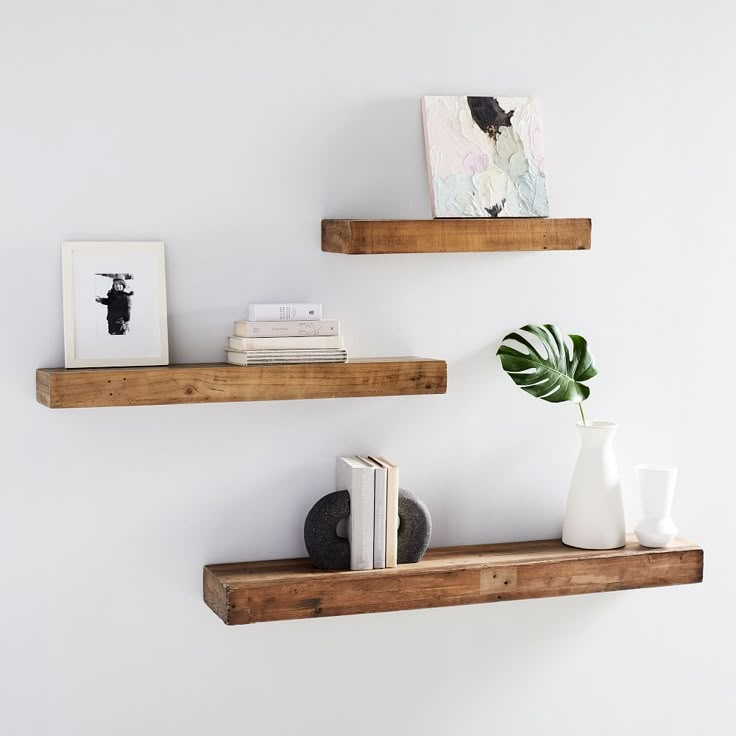 two wooden shelves with books and vases on them