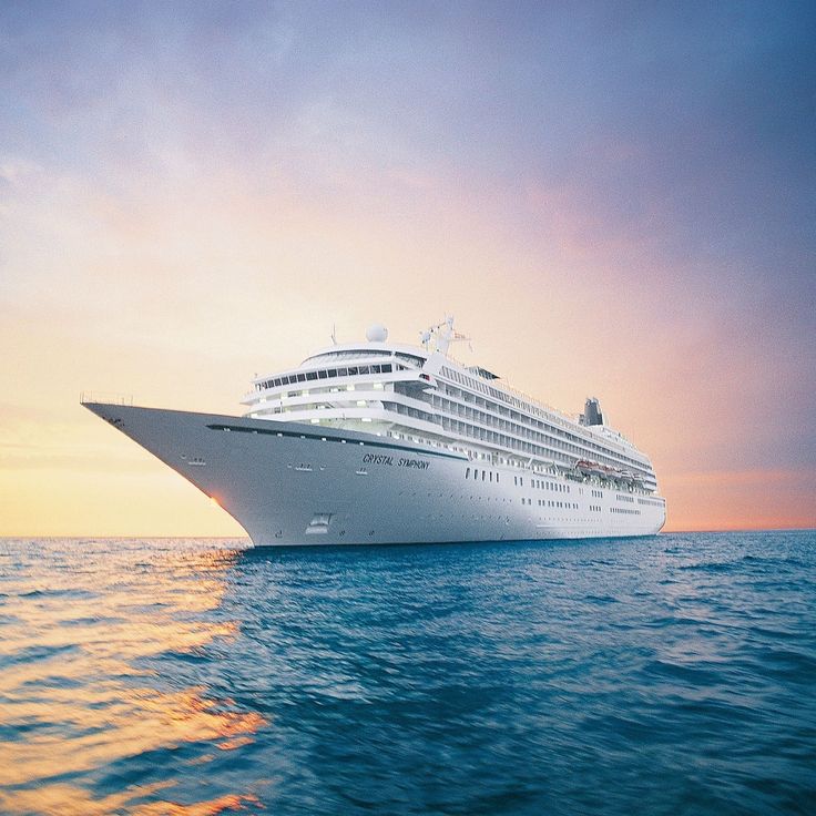 a large cruise ship in the ocean at sunset