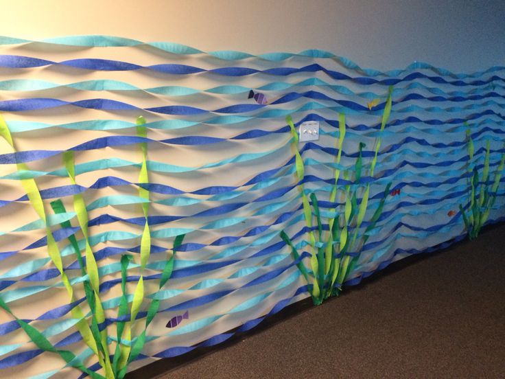 a wall made out of paper with blue and green seaweeds on it's sides