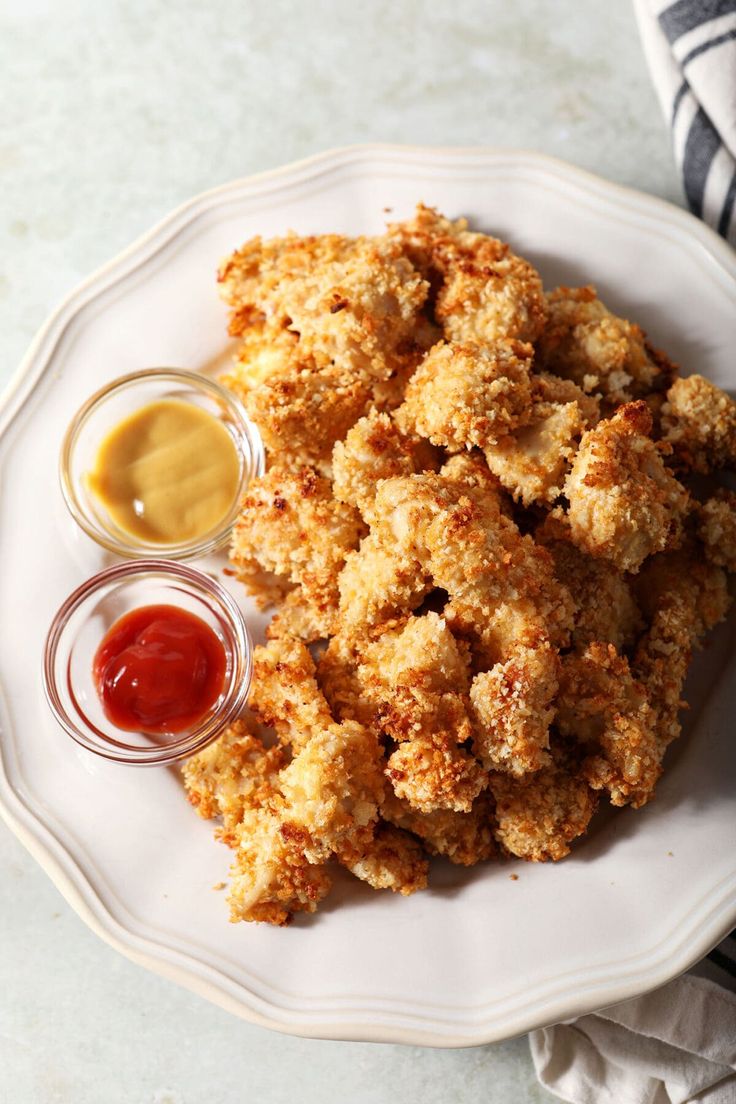 fried chicken on a plate with ketchup, mustard and mayonnaise sauce