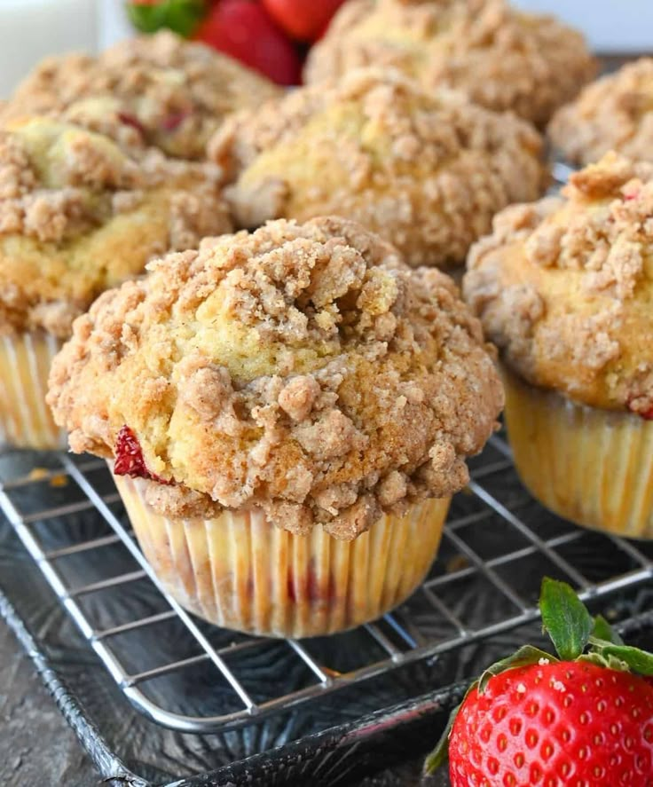 several muffins on a cooling rack with strawberries