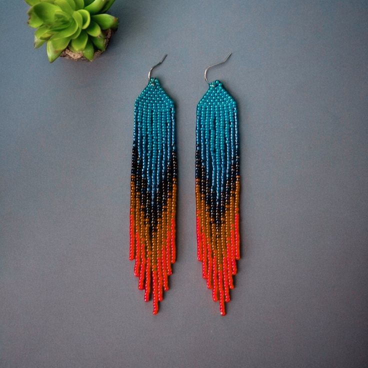 Add a vibrant touch to your outfit with these Boho Bead Ombre Fringe Earrings. Featuring a stunning blue and orange gradient, these handmade statement dangles are perfect for any bohemian style lover. The intricate beadwork creates a beautiful ombre effect, making these earrings a unique and eye-catching accessory. Ideal as a gift for her, these colorful ethnic earrings bring a pop of color and elegance to any ensemble. Elevate your jewelry collection with these exquisite, artisan-crafted fringe Bohemian Blue Dangle Tassel Earrings, Blue Bohemian Dangle Tassel Earrings, Blue Tassel Drop Earrings For Festival, Bohemian Adjustable Beaded Earrings With Large Beads, Blue Bohemian Beaded Fringe Tassel Earrings, Blue Bohemian Tassel Drop Earrings, Southwestern Blue Beaded Earrings With Round Beads, Blue Beaded Earrings With Dangling Beads For Festival, Blue Beaded Dangling Earrings For Festivals