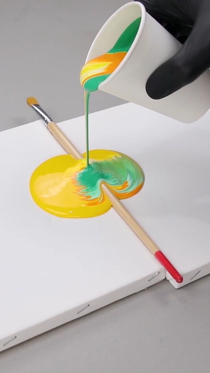 a person is painting on a piece of paper