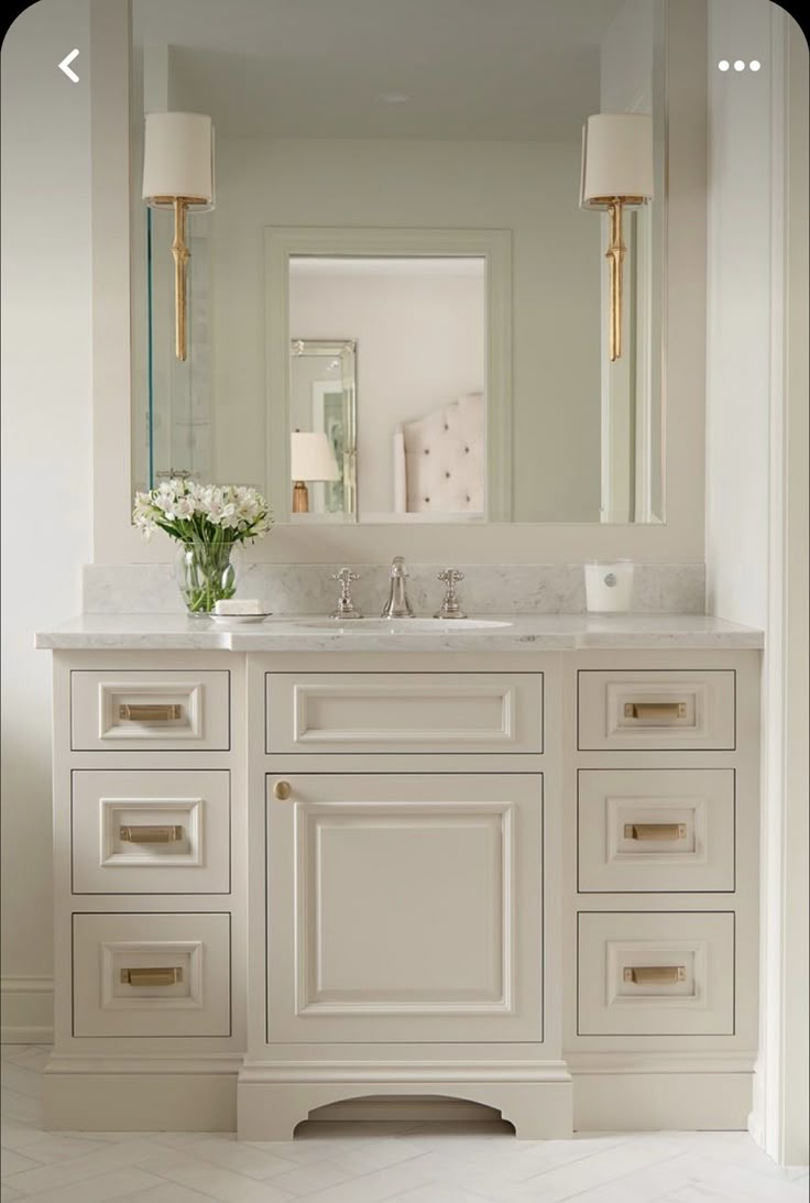 a white bathroom with two sinks and mirrors