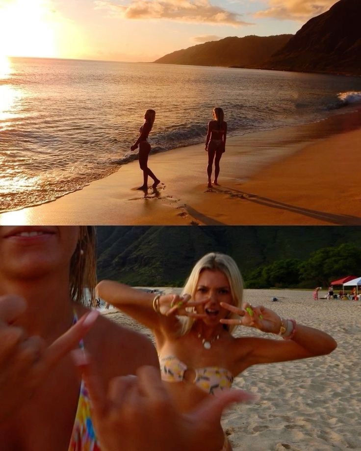 two women standing on top of a beach next to the ocean and one holding her hands up