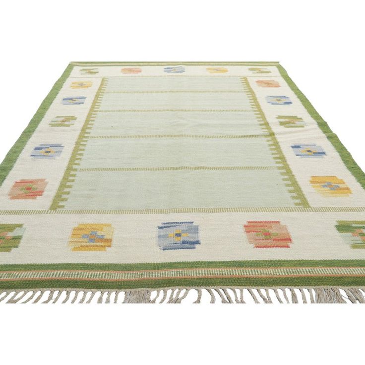 a green and yellow rug with fringes on it's sides, in front of a white background