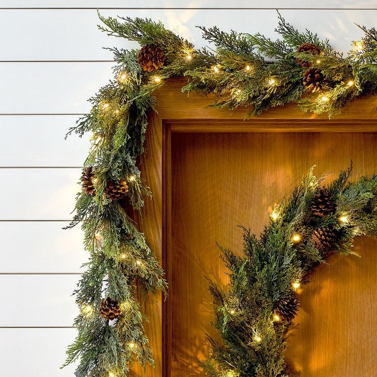 a wooden door decorated with christmas wreaths and pine cones