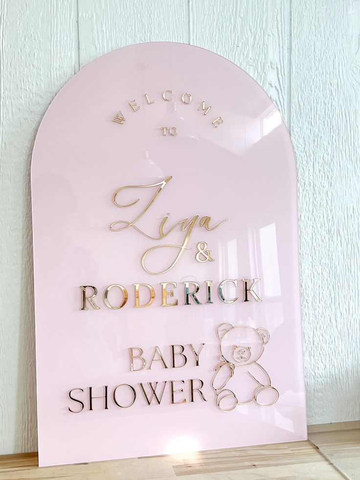 a baby shower sign with gold lettering on it