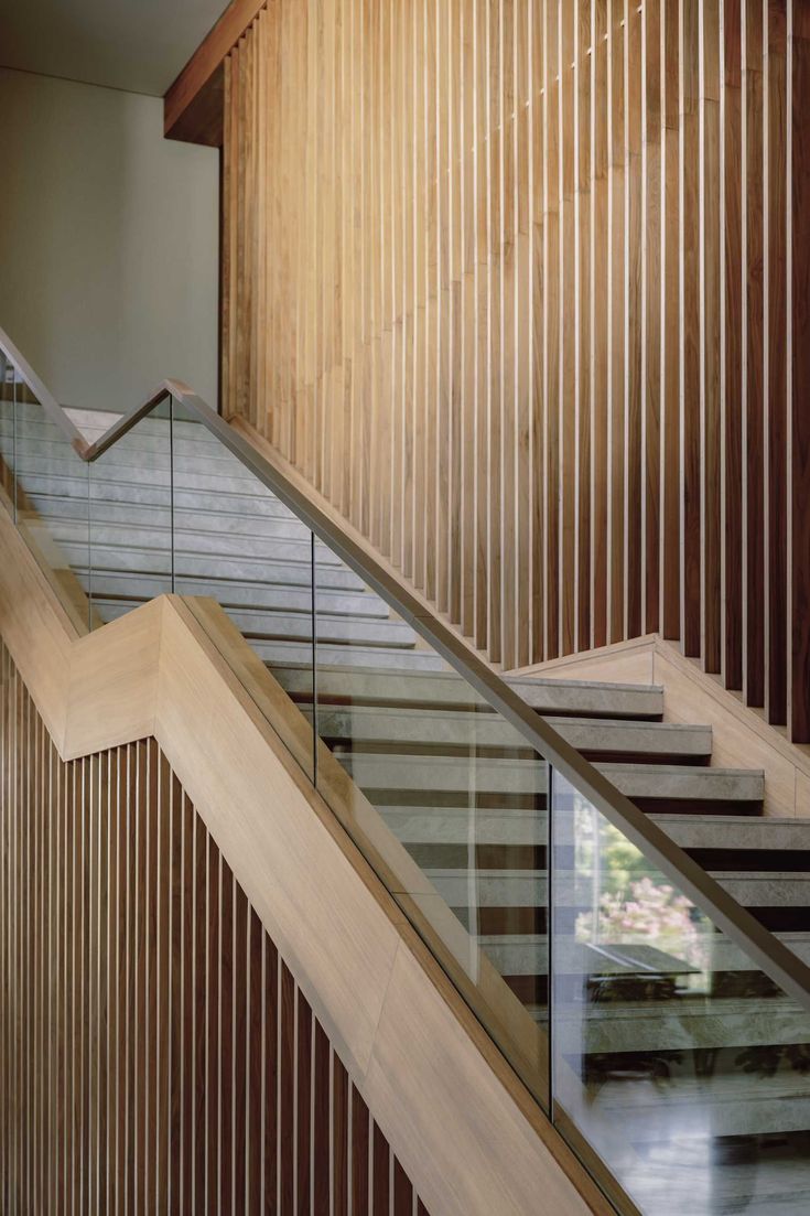 A modern home with a staircase that includes a glass and wood handrail. Glass Handrail, Staircase Handrail, Building Stairs, Timber Slats, Glass Stairs, Wood Staircase, Glass Staircase, Outdoor Dining Room, Internal Courtyard