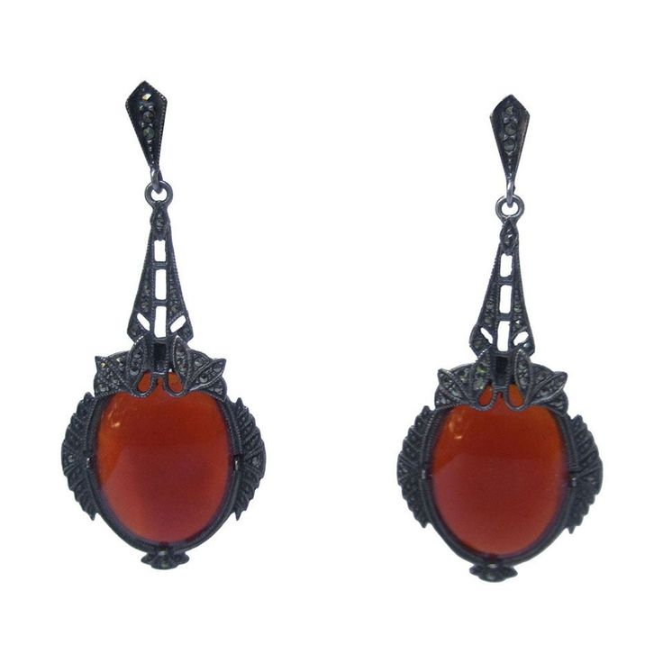 Exquisite dangling carnelian glass marcasite earrings c 1950s The ornate art deco pendant style pierced earrings are designed with large carnelian smooth oval shaped glass stones The large opaque stones are encased is pewter tone burnished metal with restrained glittering marcasites. The long dramatic earrings hang from open metal hinged panels with delicate marcasite embellishments Measurements The drop length from the pierced post to the center dangling stone base measures 2" 3/4 inches The carnelian glass stones measure 3/4 of an inch by 1" inches Czech Jewelry, Dramatic Earrings, Marcasite Earrings, Marcasite Jewelry, Carnelian Pendant, Art Deco Pendant, Vintage Inspired Jewelry, Glitter Earrings, Long Dangle Earrings