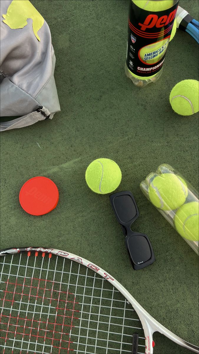 tennis rackets and balls on the ground next to a can of deodorant