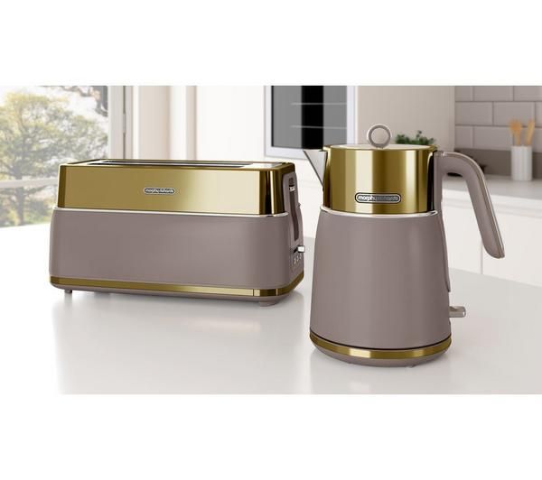 a silver and gold coffee pot sitting on top of a counter next to a toaster