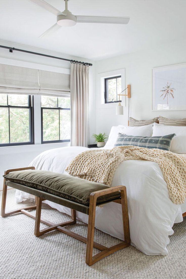 a bedroom with a bed, window and bench