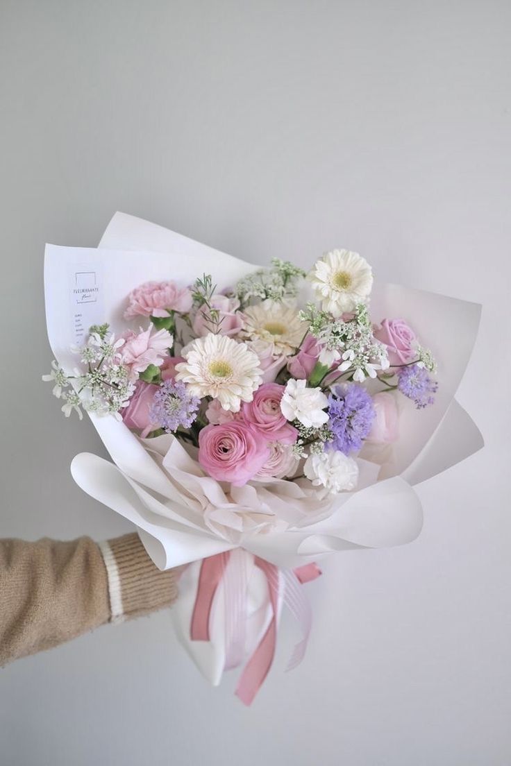 a person holding a bouquet of flowers in their hand