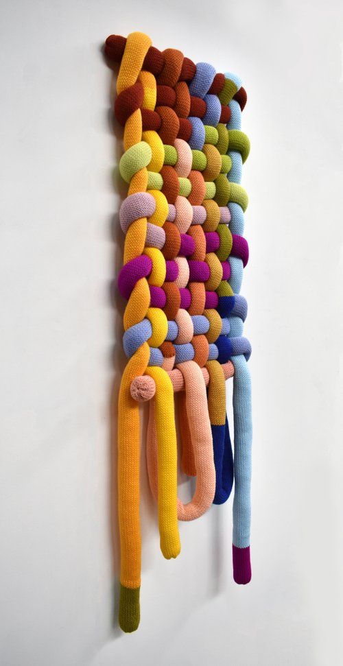 a multicolored wall hanging made out of different colored yarns and wool pom poms