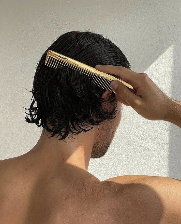 a man combing his hair with a wooden comb