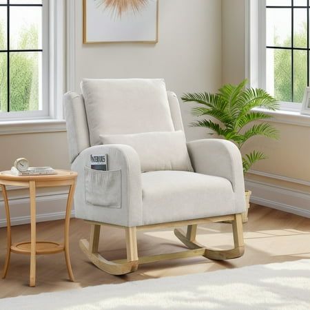 a white rocking chair sitting in front of two windows next to a table with a potted plant on it