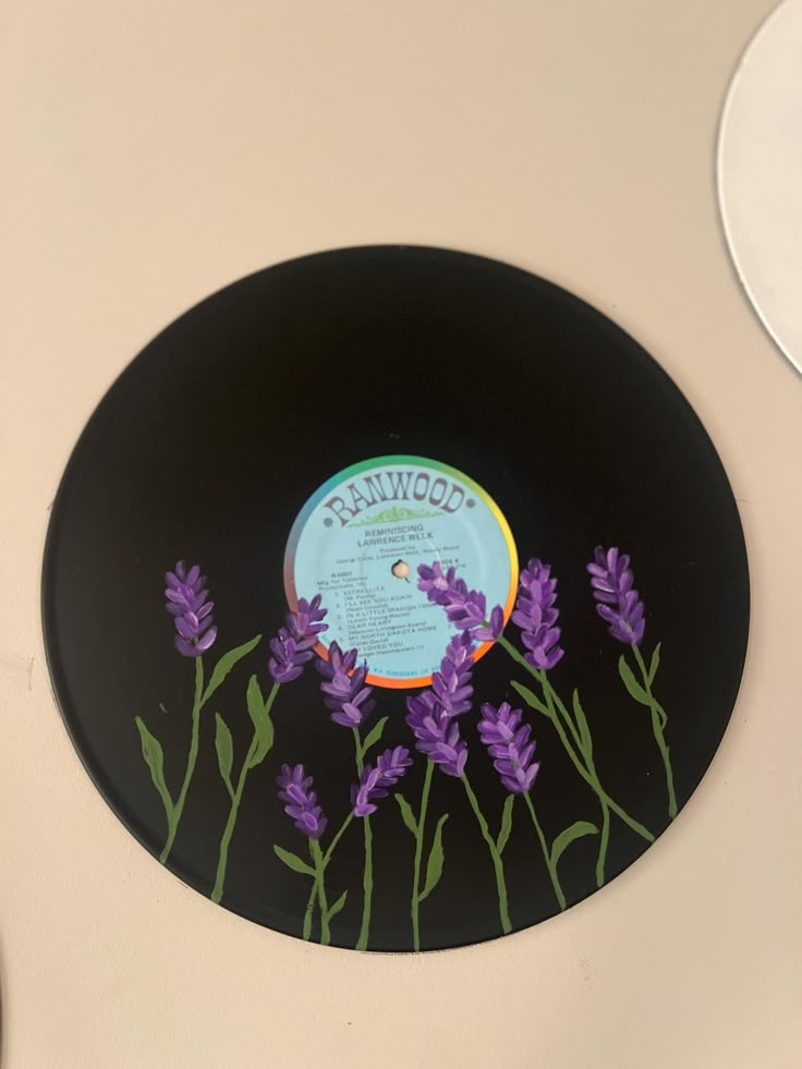 a record with purple flowers painted on it