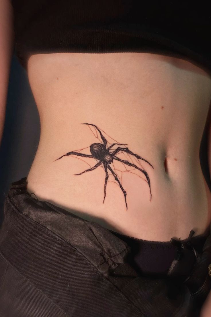 a woman with a spider tattoo on her stomach