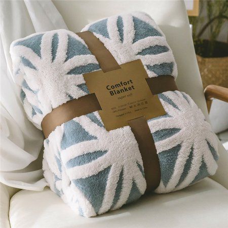 a blue and white blanket sitting on top of a chair with a brown ribbon around it