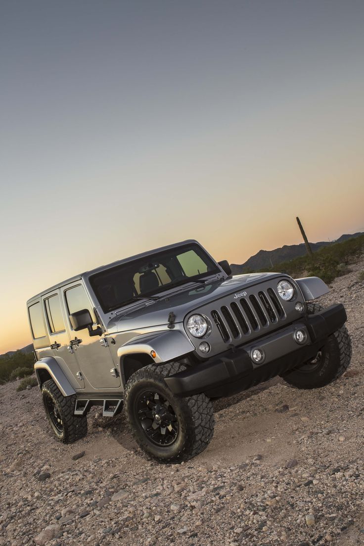 a jeep is parked in the desert at sunset