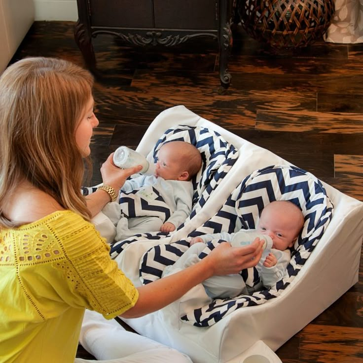 a woman is holding a bottle and feeding her baby