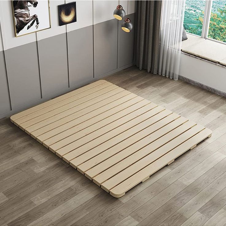 a bed that is in the middle of a room with wood flooring and white walls