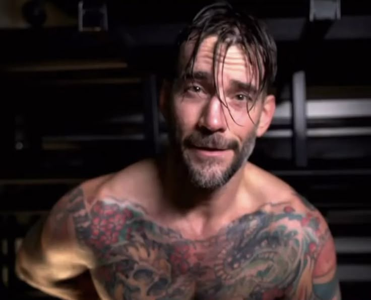 a shirtless man with tattoos on his chest and arms is looking at the camera