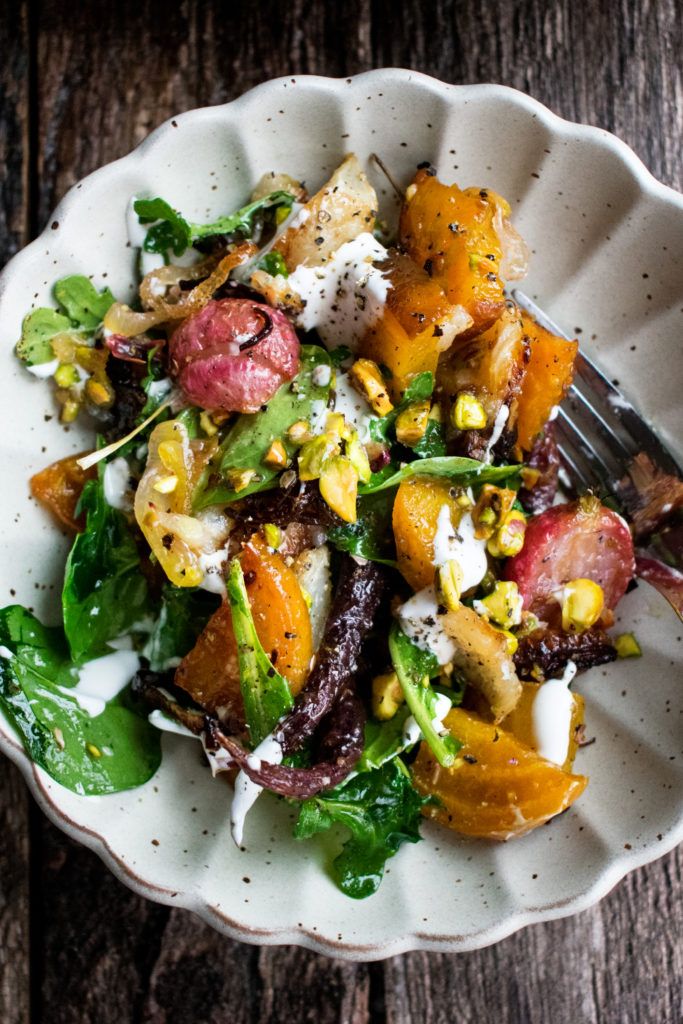 a white bowl filled with salad on top of a wooden table