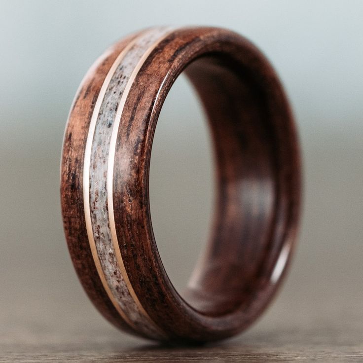 a wooden ring with silver and wood inlays on the inside, sitting on a table