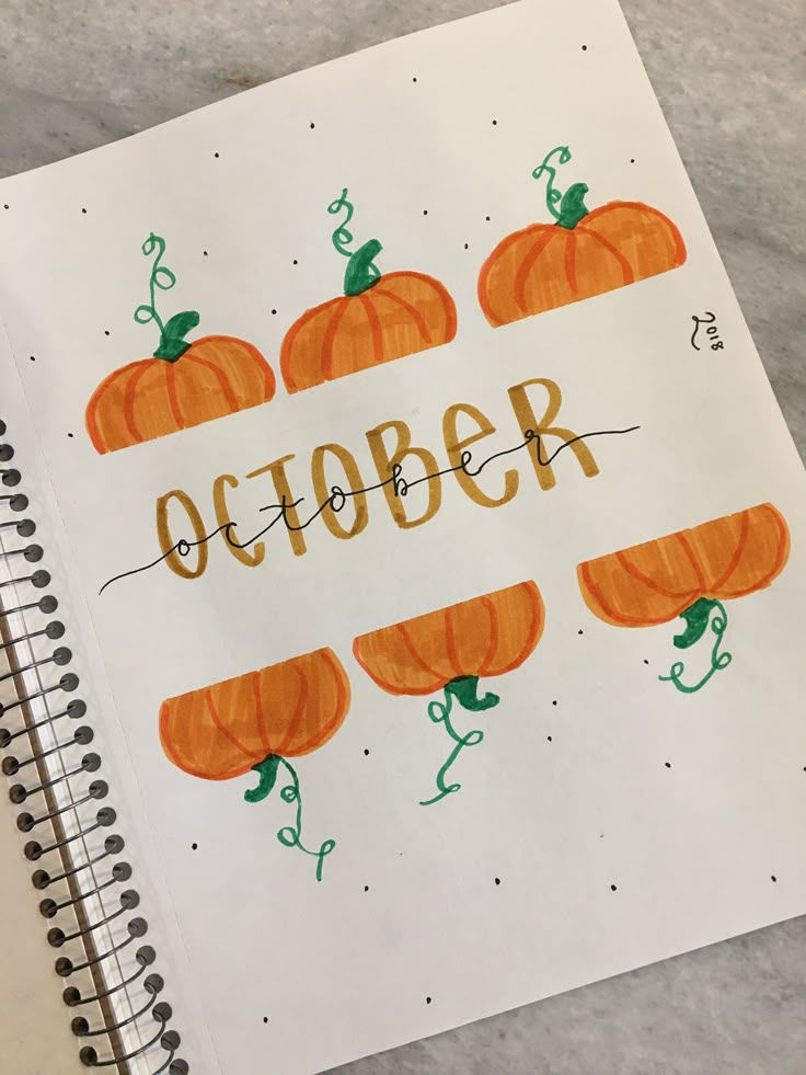 an open notebook with the words october written in orange and green pumpkins on it