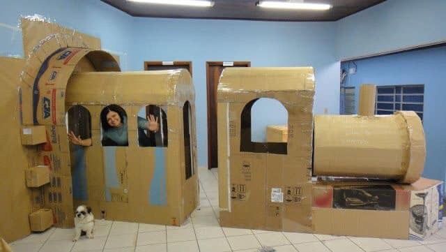 two people in cardboard castles with a dog