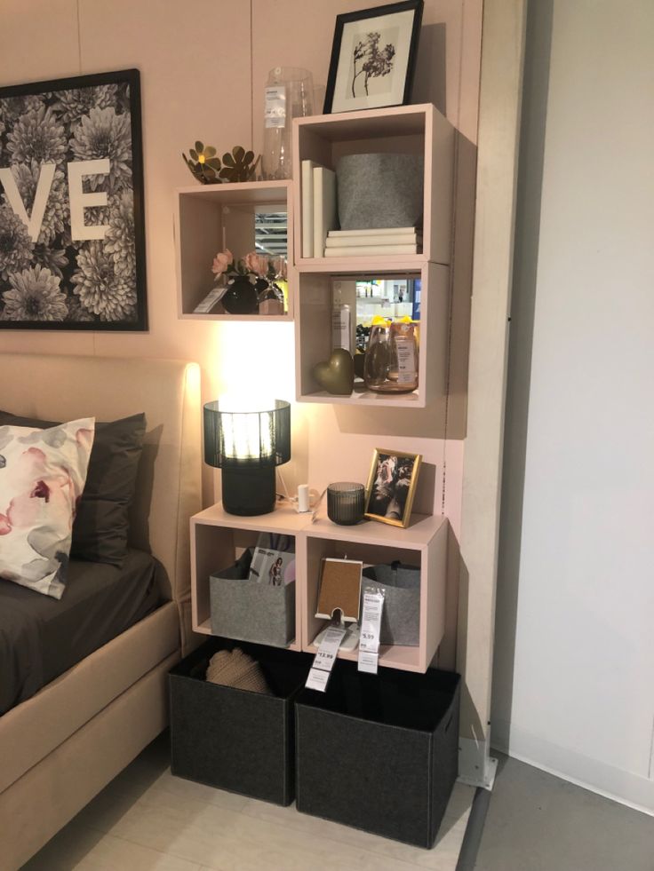 a small bedroom with a bed and shelves on the wall above it, along with other items