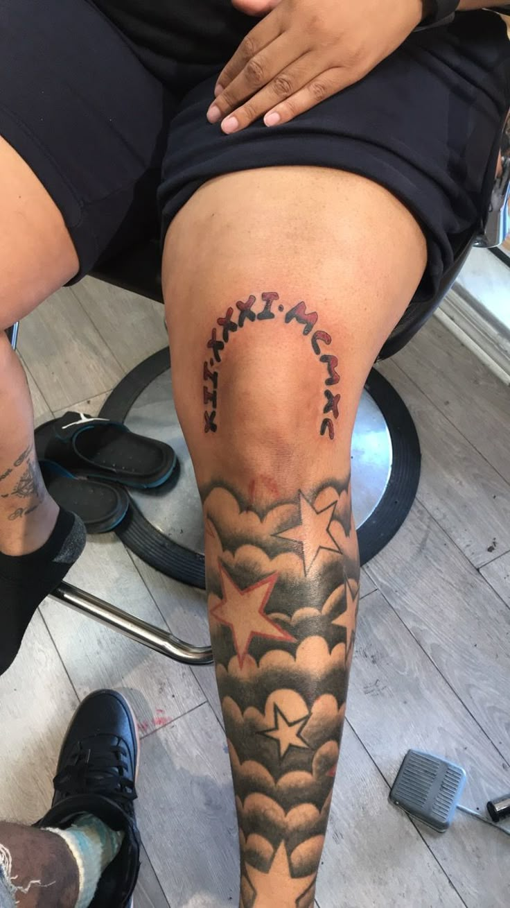 a woman sitting on top of a stool with her leg covered in clouds and stars