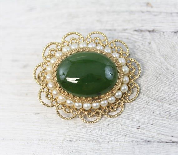 N6386Mid Century Asian 14K Yellow Gold Jade Pearl Pendant Brooch Filigree Pretty LuxuryNATURAL GREEN JADE CABOCHON WITH A ROW OF CULTURED PEARLS AROUND. FILIGREE DESIGN. AMAZING PENDANT / BROOCH PIN WONDERFUL HIGHEST QUALITY. VERY WELL MADE. JUST PART OF MY MOST RECENT ESTATE FINDS! FOLLOW ME TO SEE THEM ALL! Brand: AsianMetal Purity: 14kMetal: 14K Yellow GoldMaterial: Jade PearlForm: Pendant Brooch Filigree Pretty LuxurySize :1 1/4 x 1 3/8"Age: Mid CenturyWeight (Grams): 10.1IT IS IN EXCELLENT Green Round Brooch For Formal Occasions, Green Round Brooches For Wedding, Green Round Wedding Brooches, Elegant Green Oval Brooches, Elegant Green Filigree Brooches, Antique Green Brooch For Anniversary, Antique Green Brooches For Anniversary, Green Gemstone Brooch For Anniversary, Green Filigree Brooches For Gifts