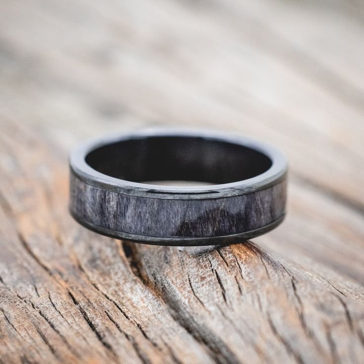 a black ring sitting on top of a wooden table