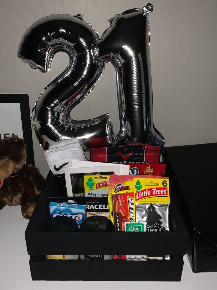 a black box filled with lots of items and a large balloon in the shape of the number twenty