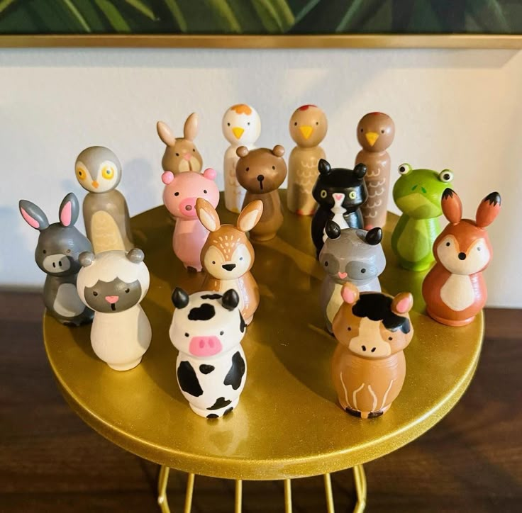 a group of small toy animals sitting on top of a wooden table next to a painting