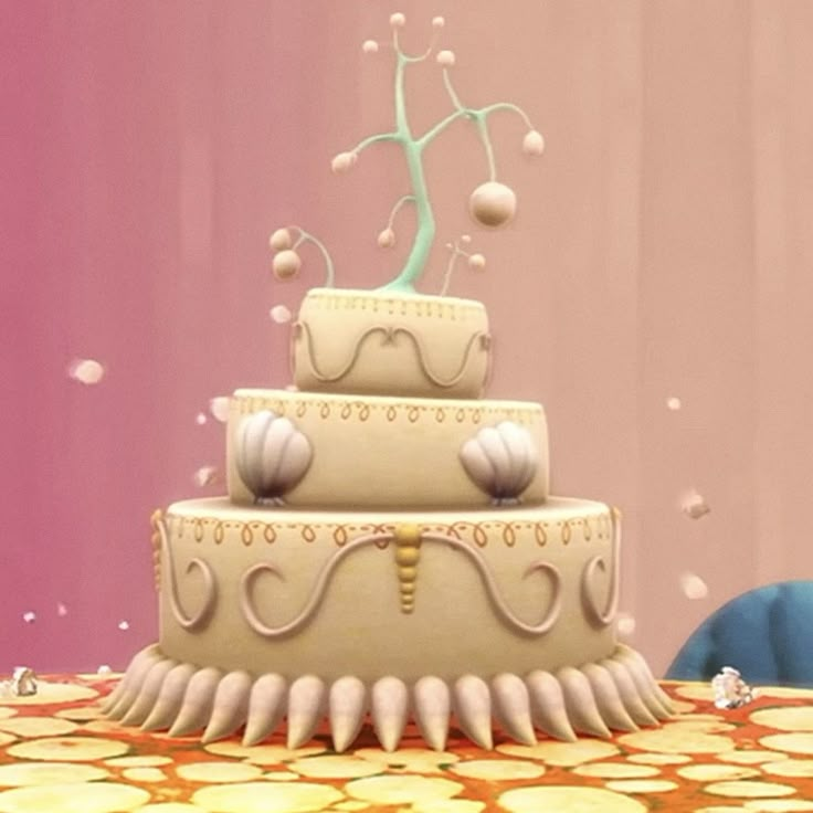 a three tiered cake sitting on top of a table next to a stuffed animal