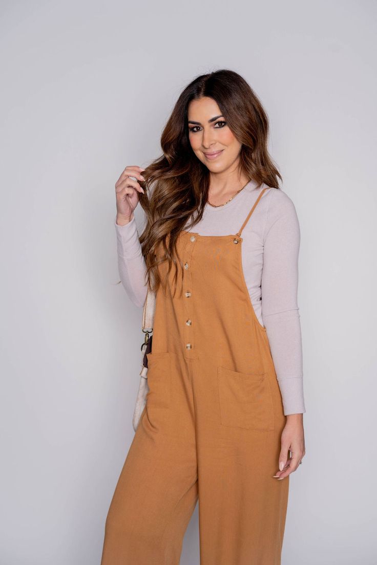 Comfy and oh so cute! This tank jumpsuit features two large front pockets, tie strap detailing, and a relaxed style fit! Put this over a tank, graphic tee, long sleeve tee, or even a sweater! This jumpsuit can be worn all year round and dressed up or down to match your style!100% Cotton Relaxed Fit Trendy Overalls For Loungewear, Trendy Relaxed Fit Overalls For Loungewear, Casual Summer Overalls With Bib Front, Casual Fall Overalls With Relaxed Fit, Casual Relaxed Fit Overalls For Fall, Chic Cotton Overalls For Loungewear, Casual Cotton Jumpsuits And Rompers, Casual Spring Jumpsuits And Rompers With Bib Front, Relaxed Fit Button-up Jumpsuits And Rompers For Day Out