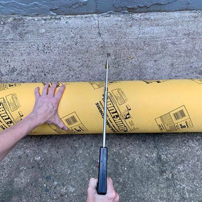 a man is holding a large piece of yellow construction tape with one hand on it