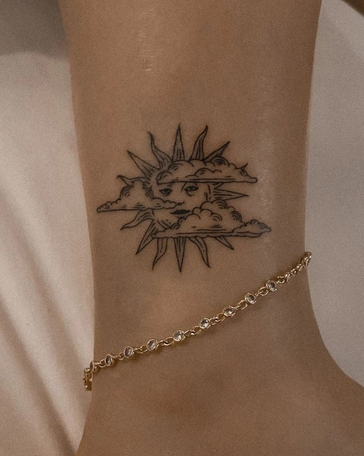 a woman's foot with a sun tattoo on the side of her ankle,